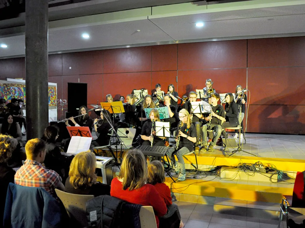 Orchester spielt vor der roten Wand.